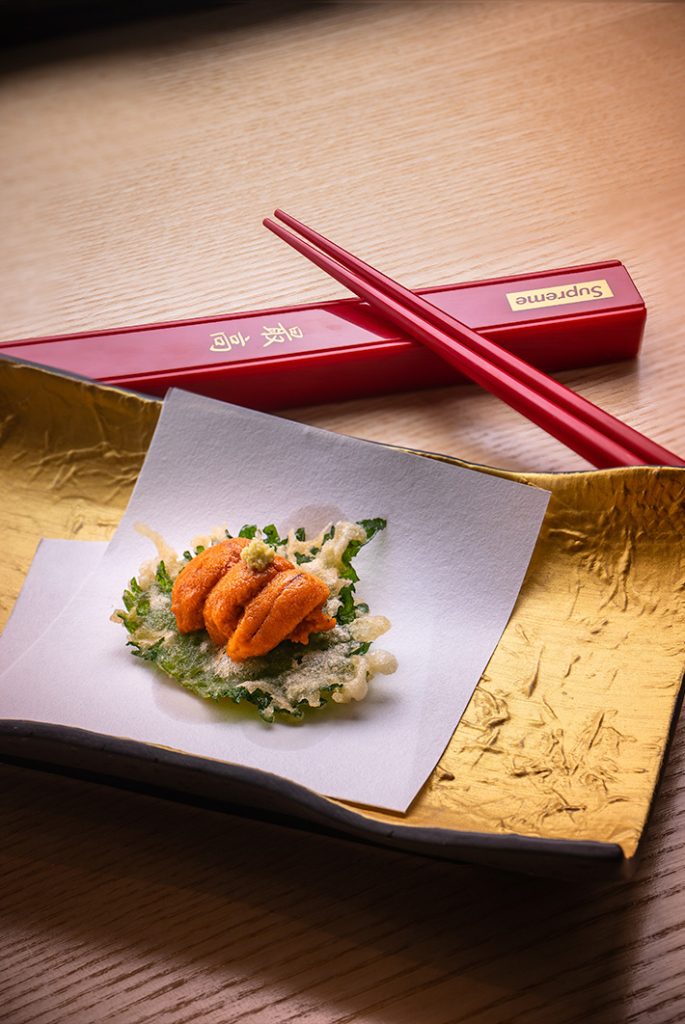Sashimi on gold leaf with red chopsticks, Curate Group