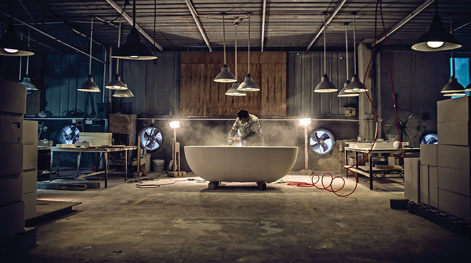 Enne Creations bathtub in a craftsman workshop under hanging lamps