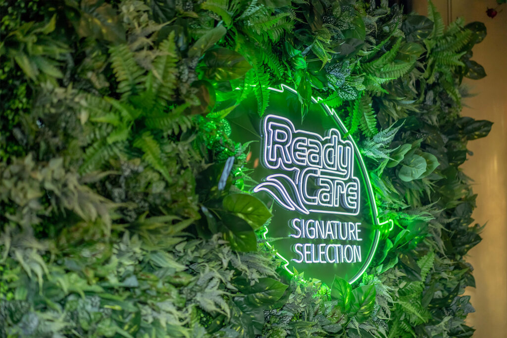 Glowing ReadyCare Signature logo on a green wall at the launch