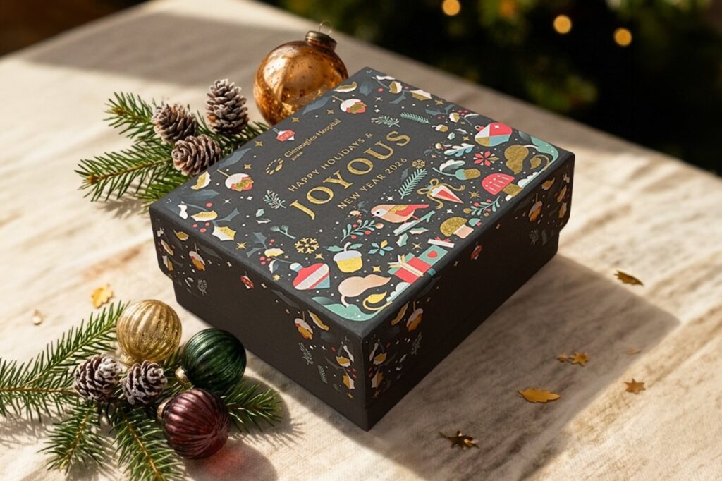 Deep green Gleneagles Hospital Johor festive gift box with a gold foil greeting and small festive drawings