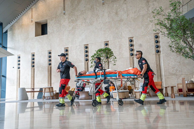 A medical team wheels a patient on a stretcher across the lobby of Menara Merdeka Maybank during the IHH Sky Race medical drill